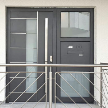 Haustüre aus Aluminium mit Milchglaseinsatz und kleinen Details in silber.